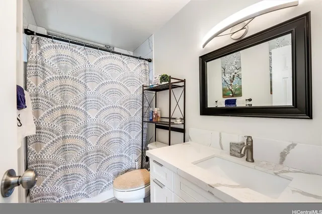 a bathroom with a granite countertop sink mirror and a bathtub