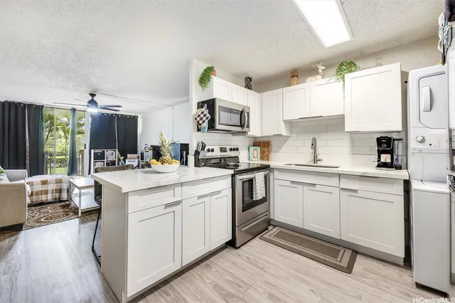 a kitchen with granite countertop a sink stove and cabinets