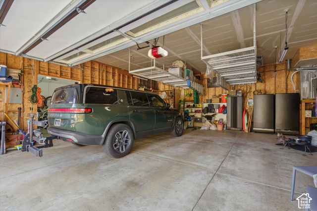 5878 Snowbasin Road Huntsville, UT 84317 - Photo 46 of 90 Concrete flooring, exposed wood framing, overhead storage racks, garage door opener, and fluorescent lighting