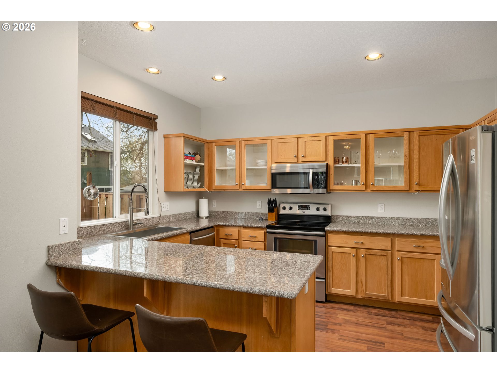8330 Southwest Norfolk Lane Portland, OR 97224 - Photo 15 of 37 a kitchen with stainless steel appliances granite countertop a sink a stove and refrigerator