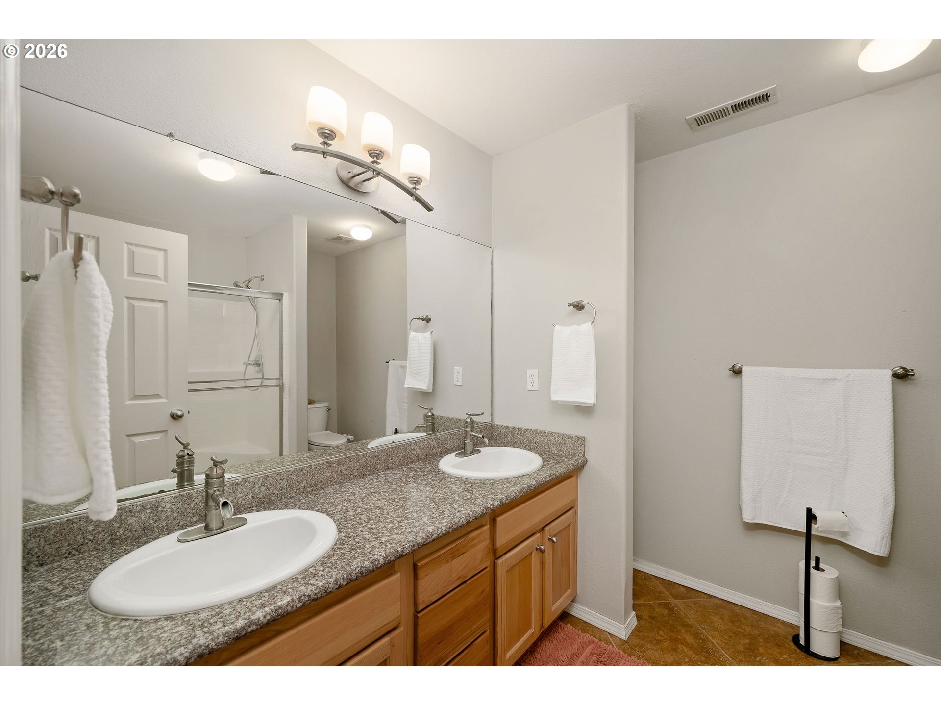 8330 Southwest Norfolk Lane Portland, OR 97224 - Photo 23 of 37 a bathroom with a granite countertop sink a mirror and a shower