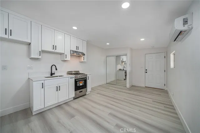 a large kitchen with cabinets and wooden floor