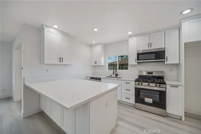 a kitchen with a stove a sink and a microwave