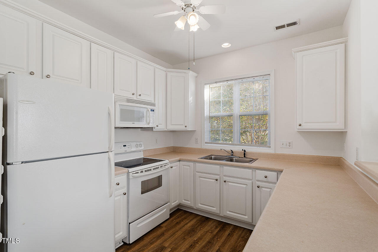 2739 Andover Glen Road Raleigh, NC 27604 - Photo 9 of 29 a kitchen with white cabinets and white appliances