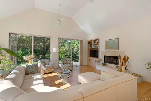 a living room with furniture a fireplace and a large window