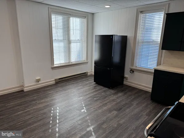 an empty room with wooden floor and a window