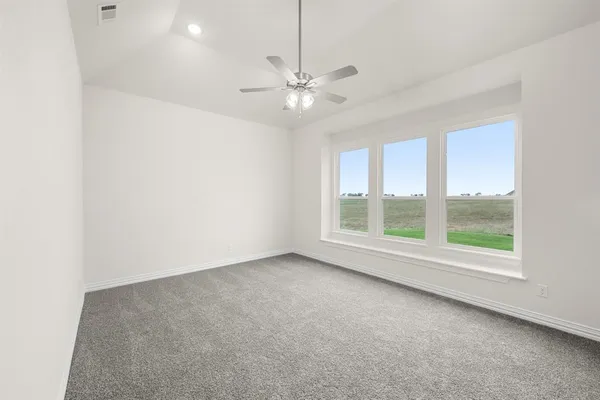 an empty room with a window and a fan