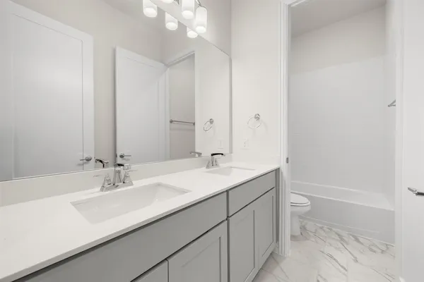 a bathroom with a sink double vanity granite tub and a mirror