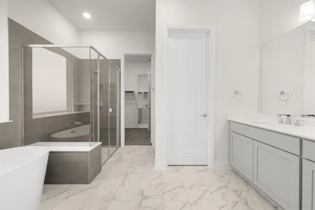 a bathroom with a tub a sink and mirror