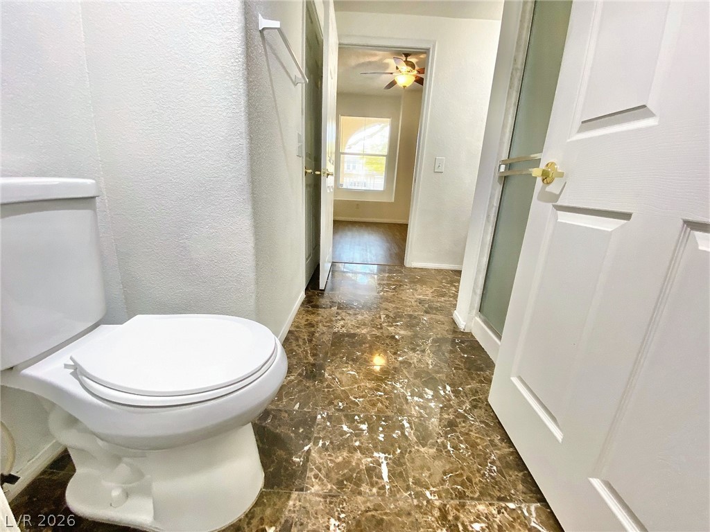 10550 West Alexander Road, Unit 1131 Las Vegas, NV 89129 - Photo 15 of 18 Marble-patterned flooring extends through this well-appointed hallway, offering a glimpse into an adjacent sun-filled room.