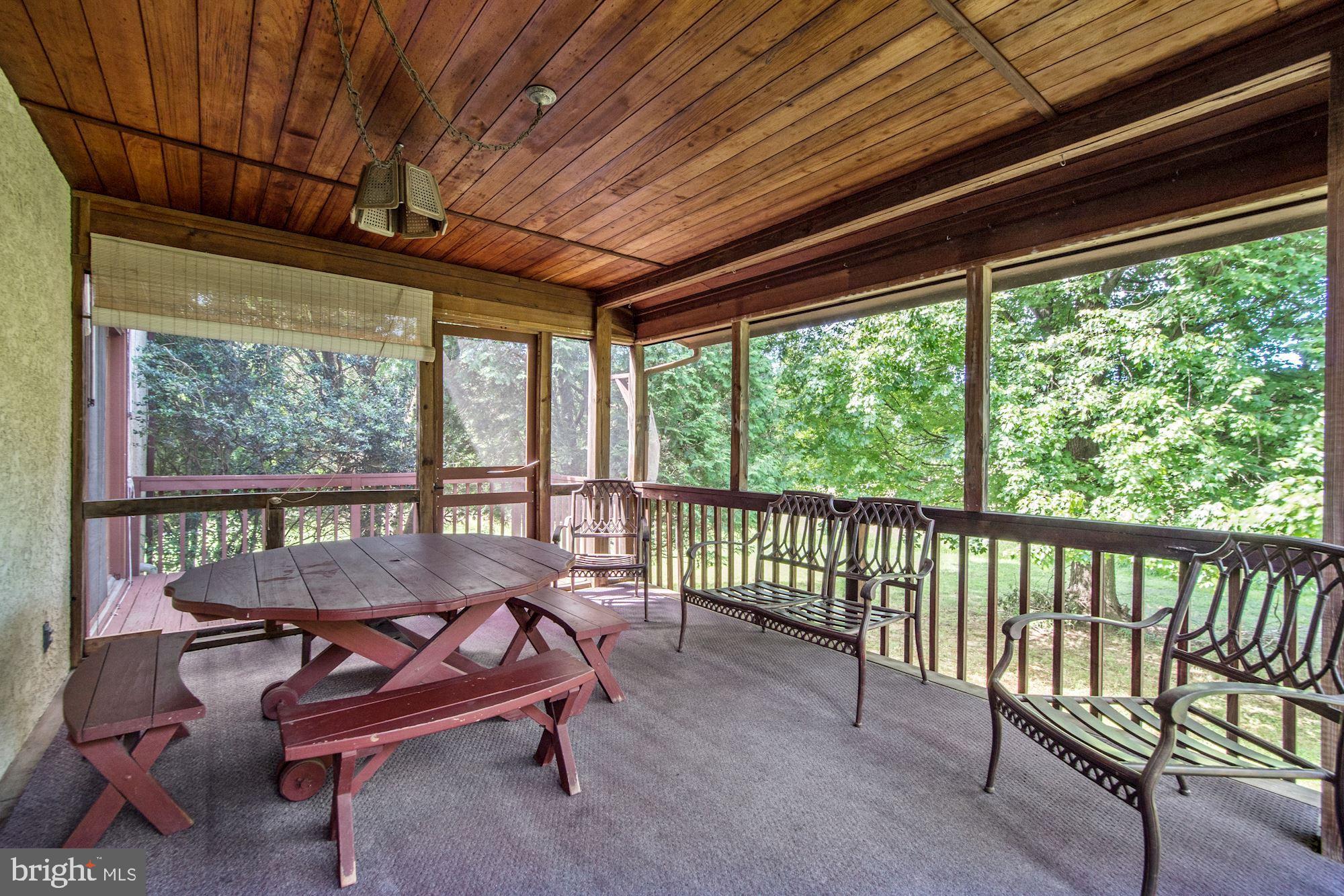 Screened-in back porch opens to a side deck