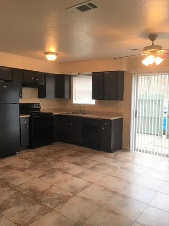 a large kitchen with kitchen island granite countertop a sink and a stove top oven