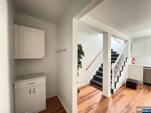 a view of hallway with stairs and wooden floor
