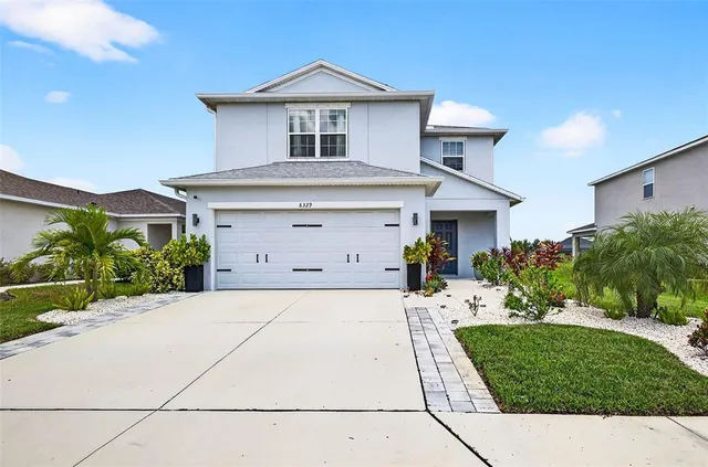 a front view of a house with a yard and garage