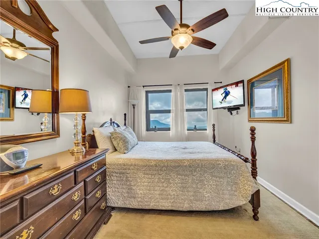 a bedroom with a bed and dresser with mirror