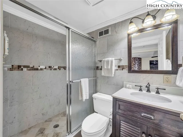 a bathroom with a sink a toilet a mirror and shower