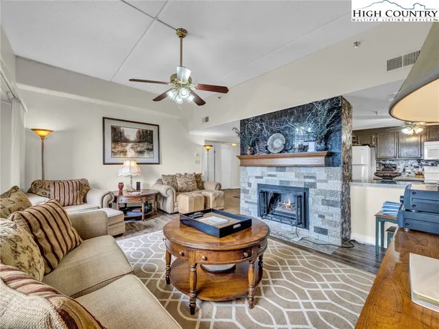 a living room with furniture a fireplace and a chandelier