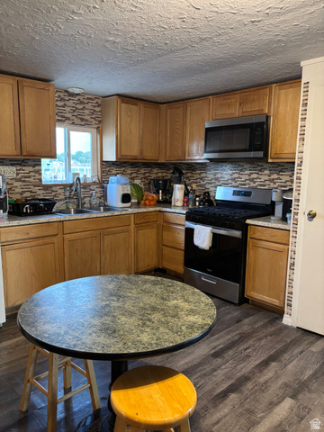615 North 250 W Road Hinckley, UT 84635 - Photo 6 of 16 Kitchen featuring wood-finish flooring, a mosaic tile backsplash, and light wood cabinetry