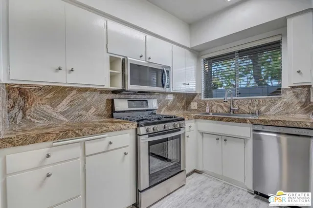 a kitchen with stainless steel appliances granite countertop a sink stove and cabinets