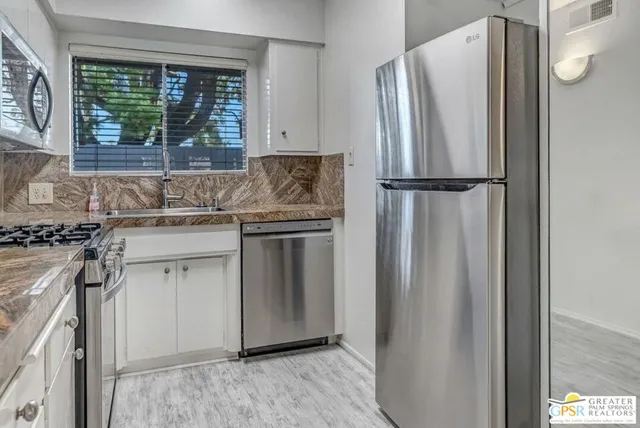 a kitchen with stainless steel appliances granite countertop a refrigerator and a sink