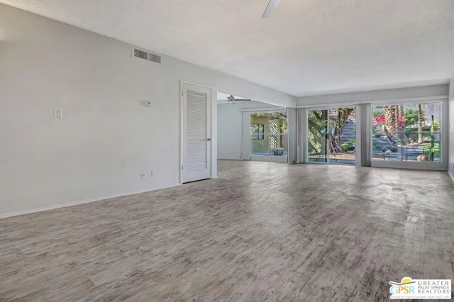 a view of an empty room with window and livingroom
