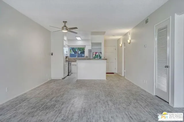 an empty room with kitchen and a window