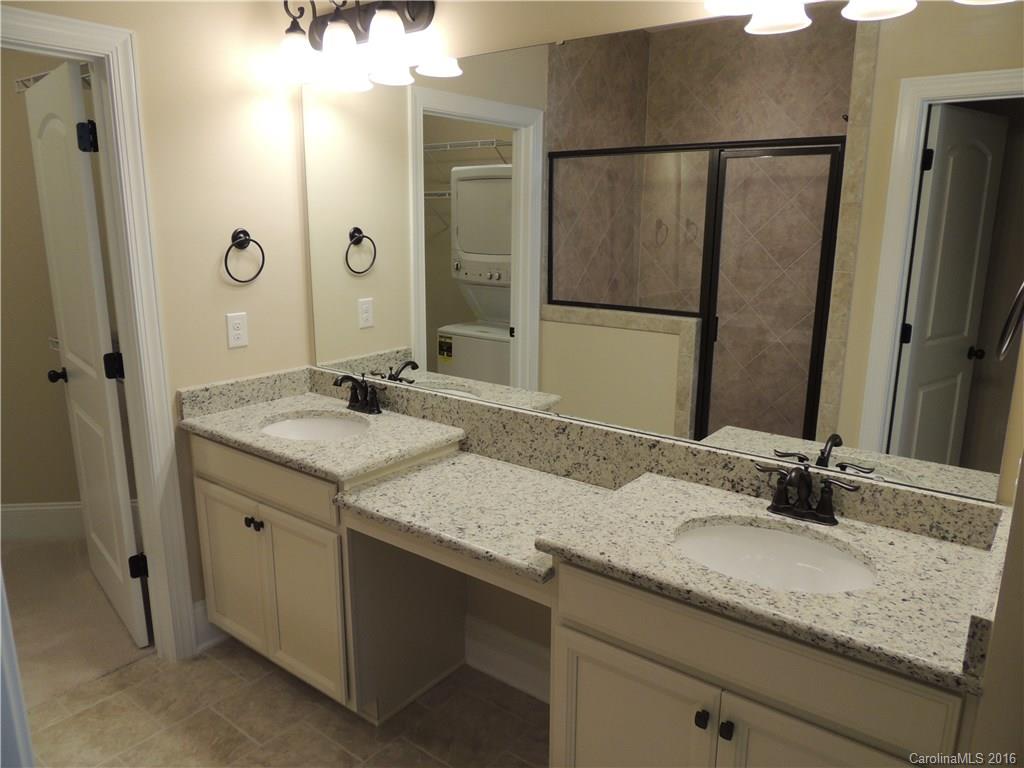 905 Ospre Lane, Unit 142 Fort Mill, SC 29708 - Photo 11 of 24 a bathroom with a granite countertop sink and a mirror