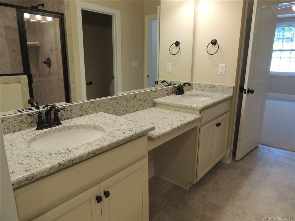 905 Ospre Lane, Unit 142 Fort Mill, SC 29708 - Photo 12 of 24 a bathroom with a granite countertop sink and a mirror