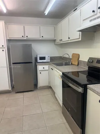 a kitchen with a stove a sink and a refrigerator