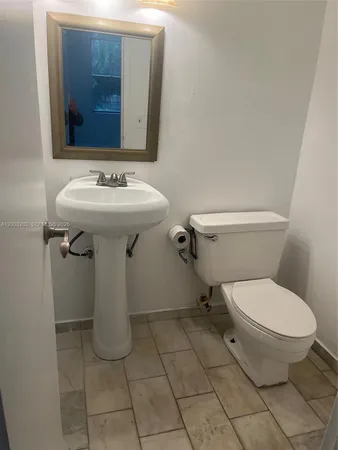 a bathroom with a sink toilet and mirror