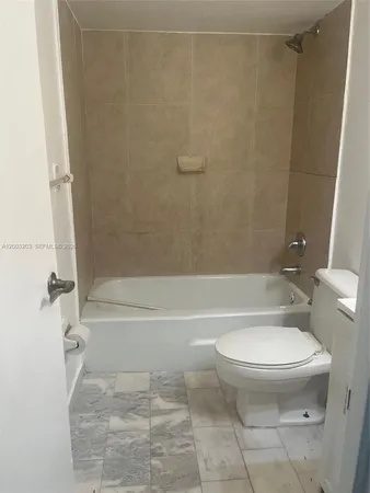 a bathroom with a toilet and a bath tub