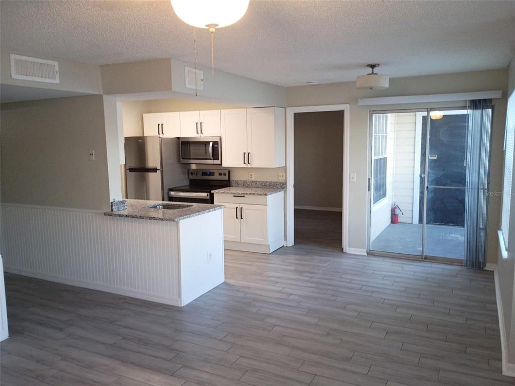 1037 South Hiawassee Road, Unit 2818 Orlando, FL 32835 - Photo 3 of 11 a view of kitchen with wooden floor and electronic appliances