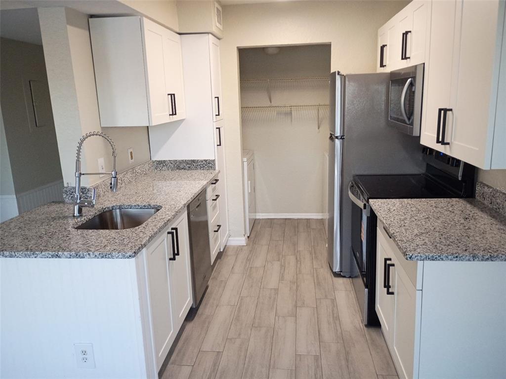 1037 South Hiawassee Road, Unit 2818 Orlando, FL 32835 - Photo 8 of 11 a kitchen with stainless steel appliances granite countertop a sink stove and refrigerator