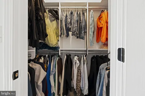 a view of walk in closet with clothes and shoes