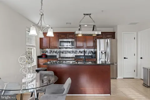 a kitchen with stainless steel appliances granite countertop a sink a stove and a refrigerator