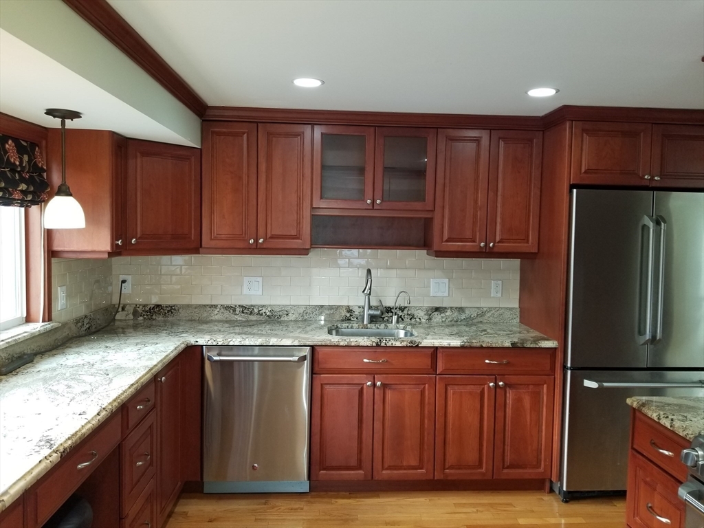 225 Governors Road, Unit 225 Quincy, MA 02169 - Photo 4 of 19 a kitchen with stainless steel appliances granite countertop wooden cabinets a stove top oven a sink and dishwasher