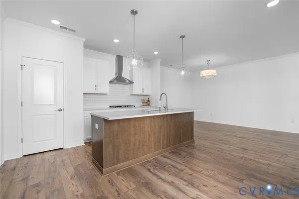a large kitchen with granite countertop a white stove top oven and white cabinets