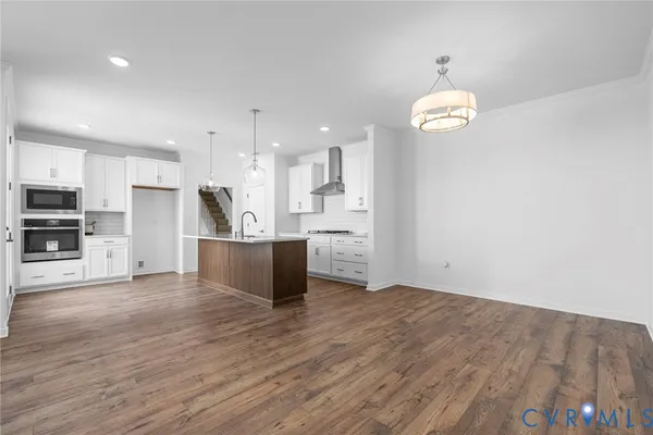 a view of kitchen with stainless steel appliances refrigerator stove microwave and cabinets