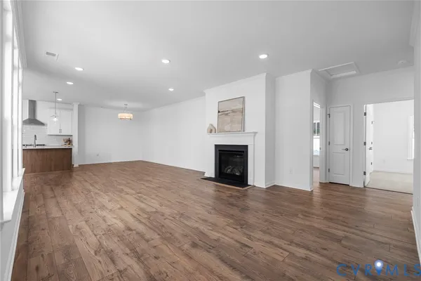 a view of empty room with wooden floor and fireplace
