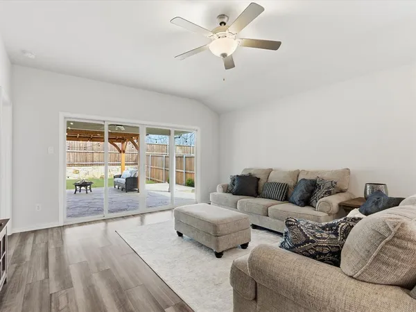 a living room with furniture and a large window with wooden floor