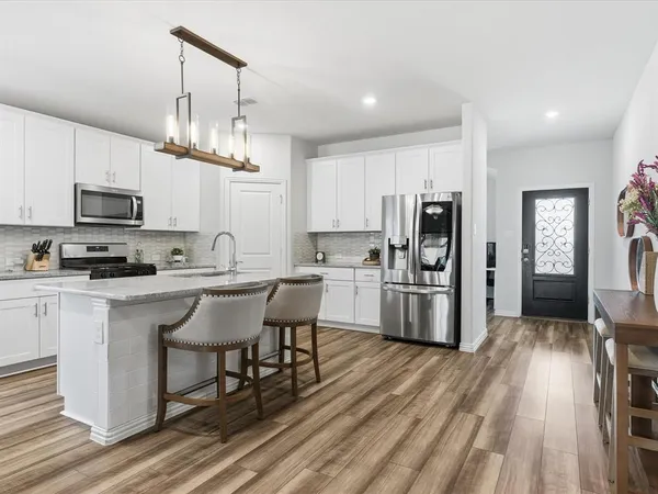 a kitchen with kitchen island granite countertop a center island stainless steel appliances and cabinets