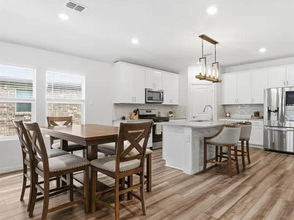 a view of kitchen with cabinets table and chairs