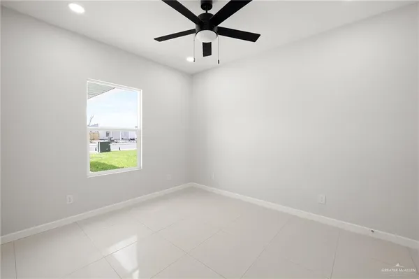 an empty room with a window and a ceiling fan