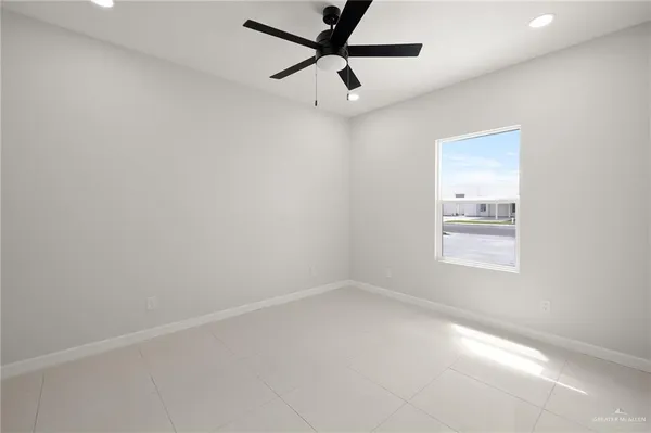 an empty room with a window and a fan