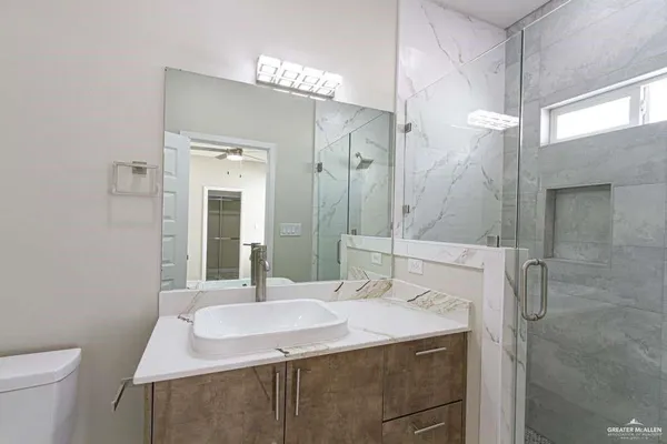 a bathroom with a sink a toilet and shower