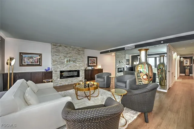 a living room with furniture floor to ceiling window and wooden floor
