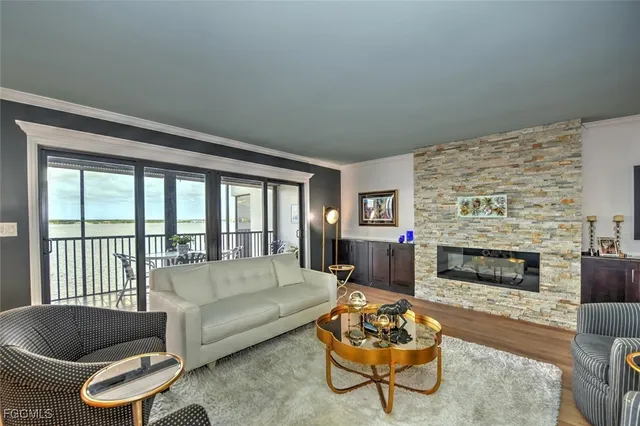 a living room with furniture a fireplace and a large window