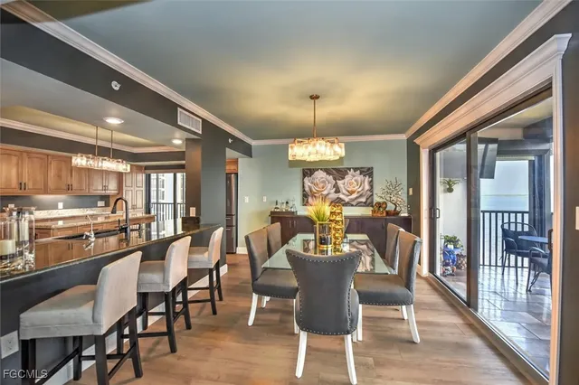 a dining room with furniture a chandelier and wooden floor