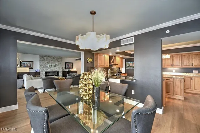 a view of a dining room and livingroom with furniture wooden floor a chandelier