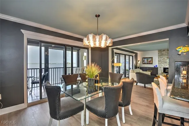 a dining room with furniture a chandelier and wooden floor